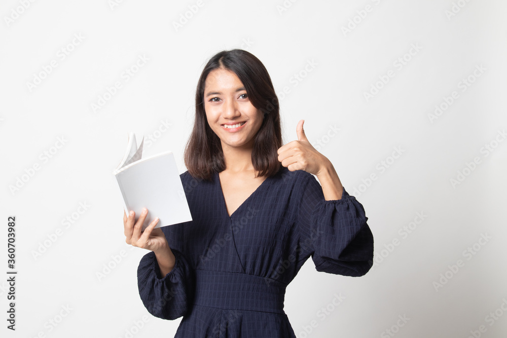 Young Asian woman thumbs up with a book. Young Asian woman thumbs up with a book.