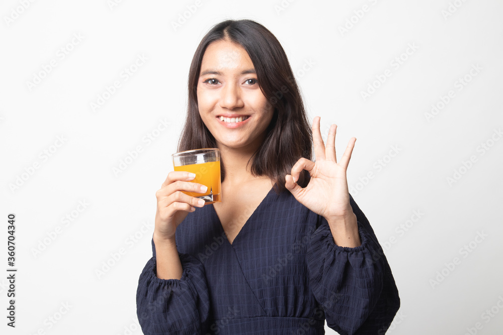 Young Asian woman drink orange juice show OK sign. Young Asian woman drink orange juice show OK sign.