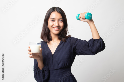 Healthy Asian woman drinking a glass of milk and dumbbell.
