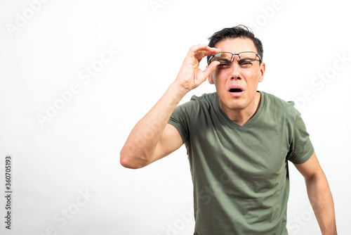 Man with glasses straining his eyes because he can't see well. photo