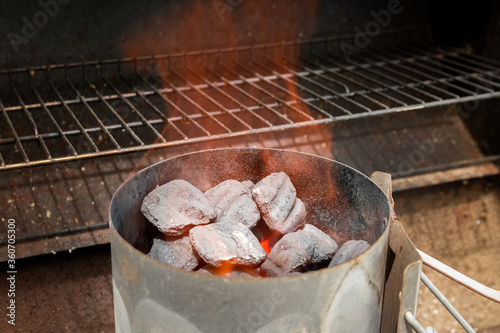Flames rising out of charcoal chimney starter