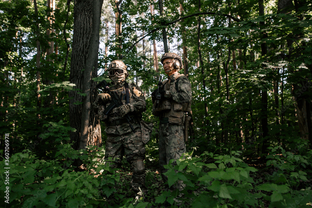 Two soldiers with weapons in the forest
