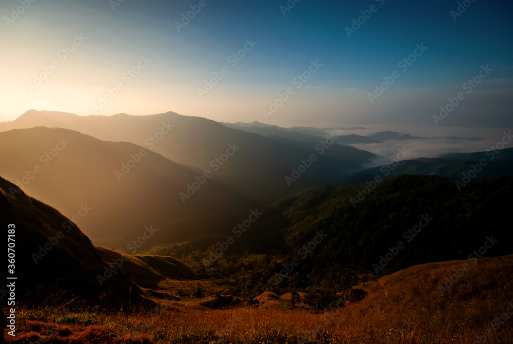 beautiful blue sky and mountains in the mornings of summer. And there is a sea of mist inserted between the valleys With dry meadows foreground
