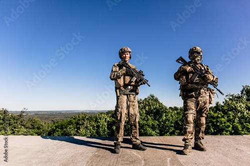 Two American army soldiers standing on the roof of a building