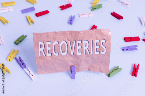 Text sign showing Recoveries. Business photo text process of regaining possession or control of something lost Colored clothespin papers empty reminder blue floor background office pin photo