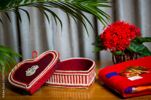 Handmade fiber ornaments box with traditional jewelry on the wooden table. Indian traditional jewelry and Bridal saree. photo