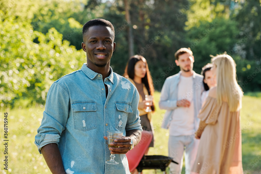 Happy young African man with glass of white wine standing in front of camera Happy young African man with glass of white wine standing in front of camera
