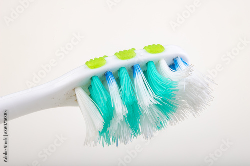 Toothbrush on a white table. Heavily worn bristles in a personal hygiene brush.