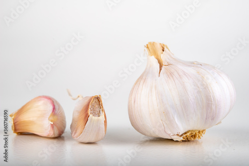A whole head of garlic and a few cloves of garlic. Vegetables used in home cooking.