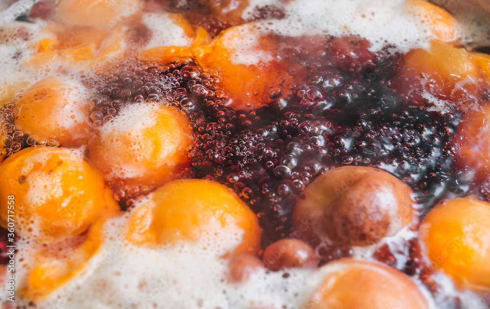 Fresh fruits are boiled in boiling water in a metal pan on a stove with bubbles and foam close-up. Cooking a delicious compote of apricot, apples, cherries, raspberries. Photography, concept. Fresh fruits are boiled in boiling water in a metal pan on a stove with bubbles and foam close-up. Cooking a delicious compote of apricot, apples, cherries, raspberries. Photography, concept.