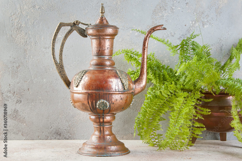 Antique copper jug with lid on concret background. Antique copper jug with lid on concret background.