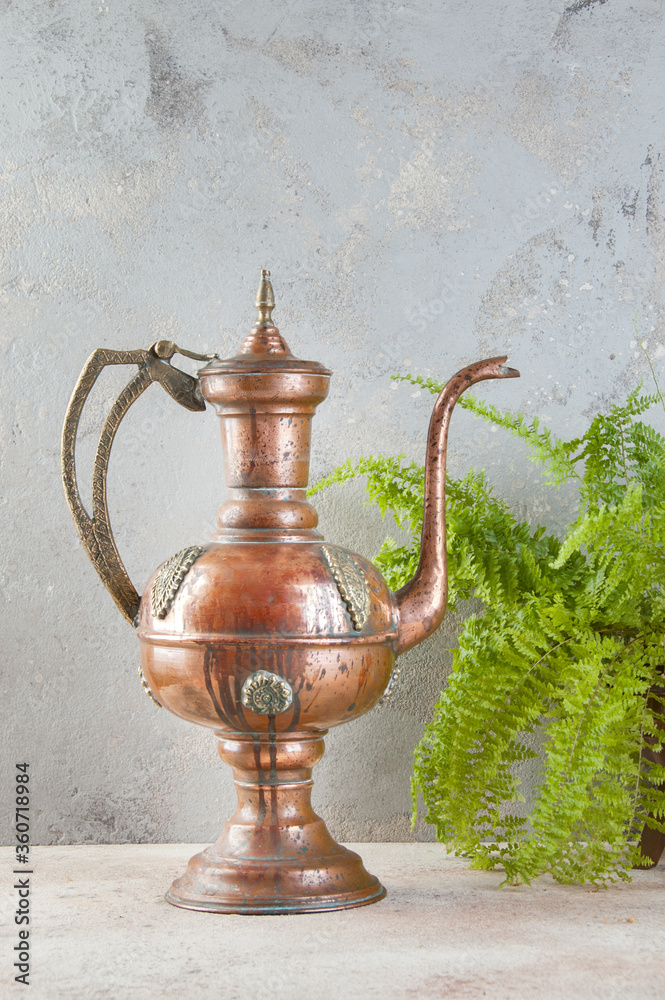 Antique copper jug with lid on concret background. Antique copper jug with lid on concret background.