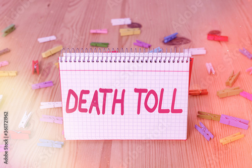 Handwriting text writing Death Toll. Conceptual photo the number of deaths resulting from a particular incident Colored clothespin papers empty reminder wooden floor background office photo