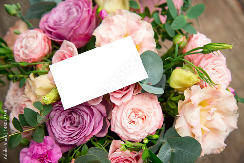 Mockup business card on a bouquet of pink roses
