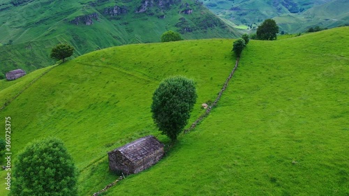 Aerial view with a drone of the spring landscape of pasiegas cabins and meadows in the Miera Valley in the Autonomous Community of Cantabria. Spain, Europe