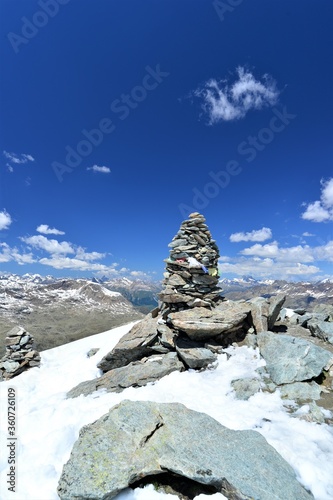 cairn in the swiss mountains in grisons with blue sky in the background