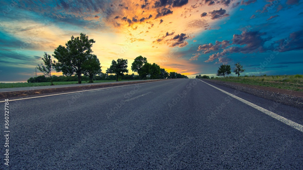 Naklejka premium highway goes to the horizon between the fields