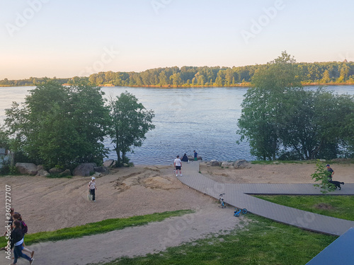 Russia, Saint-Petersburg 25.06.2020 Beach near the lake, people walk photo