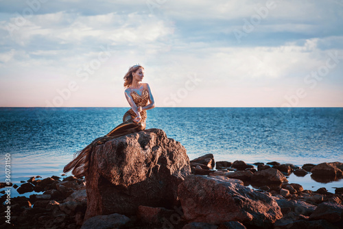 Fotografia Sadness mermaid, nixie, water nymph sitting on stone