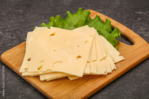 Sliced yellow cheese over board