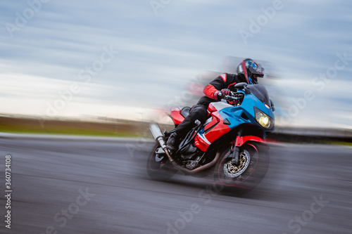 biker on a motorcycle rides on the road, blurring from speed