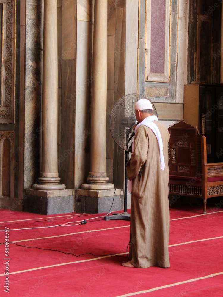 A man performing his prayer in the old beautiful decorated mosque of Sultan Hassan in Cairo