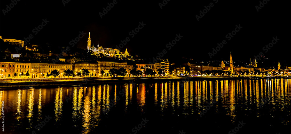 A view from the Chain Bridge across the River Danube in Budapest at night towards the Buda district in the summertime