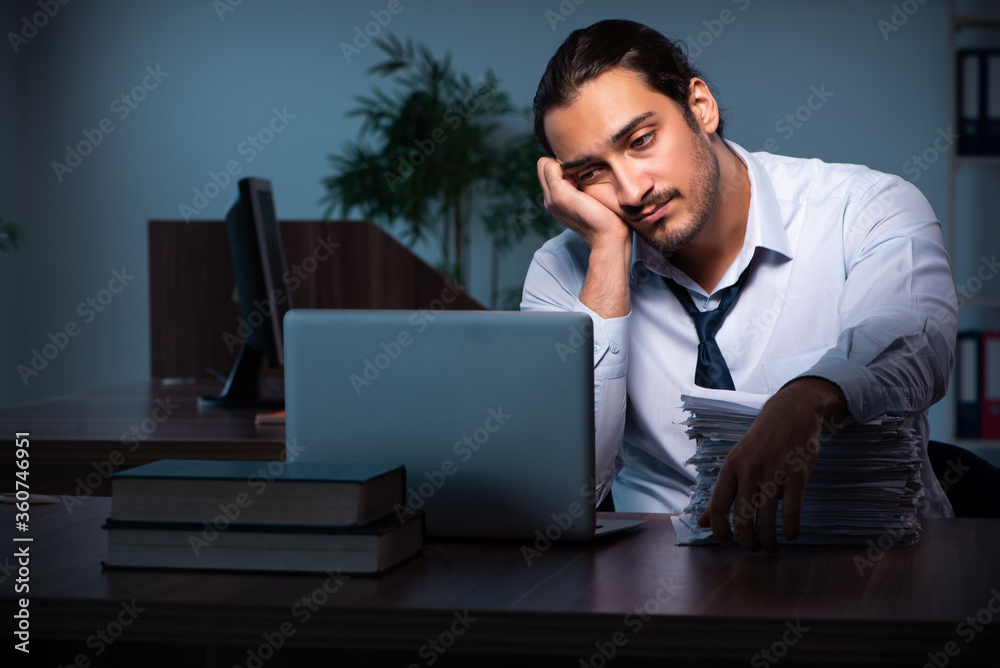 Young male employee working in the office night time Young male employee working in the office night time