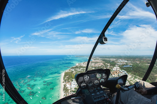 Helicopter cabin inside cockpit aerial top view on blue sky and water at the caribbean coast and atlantic ocean in Dominican republic, Punta Cana