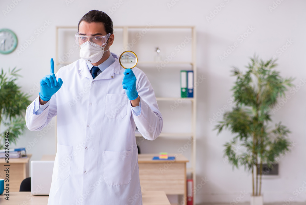Fototapeta premium Young male doctor virologist in the office