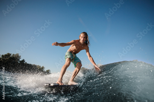 Sportsman balancing on wake board down the river waves