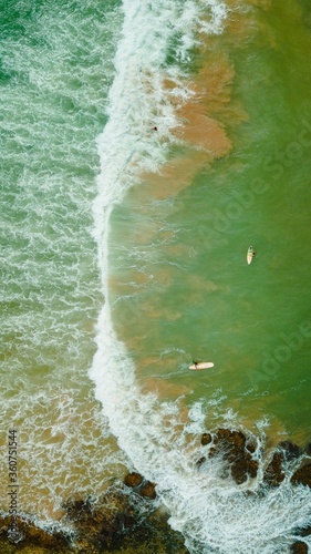 Photography Aerial breathtaking shot of the surfers surfing on the ocean wave