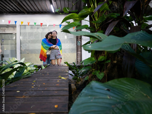 Two embracing same-sex marriage girls with rainbow flag photo