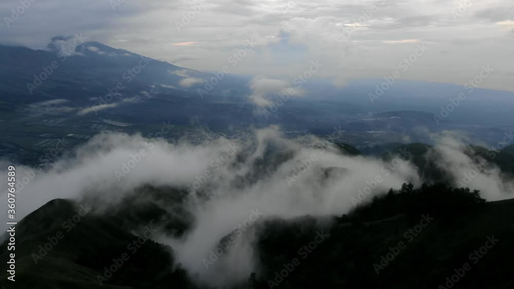 Aerial view moving shot, scenic view moving up mists covering Pergasingan Hill in Lombok Indonesia. Aerial view moving shot, scenic view moving up mists covering Pergasingan Hill in Lombok Indonesia.