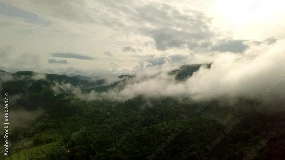 Aerial view flying thru the morning rain cloud covered tropical rain forest mountain landscape during the rainy season on the Doi Phuka Mountain reserved national park the northern Thailand