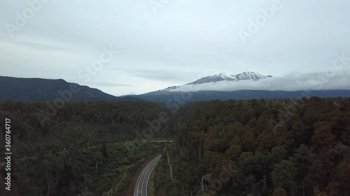 4K Makatote Viaduct drone footage. drone  shot flying over forest, road and cars passing by with Mount Ruapehu as background in Tongariro, New Zealand. photo