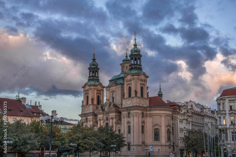 St. Nicholas Church Prague Old Town Square at dawn with dramatic sky and clouds no people