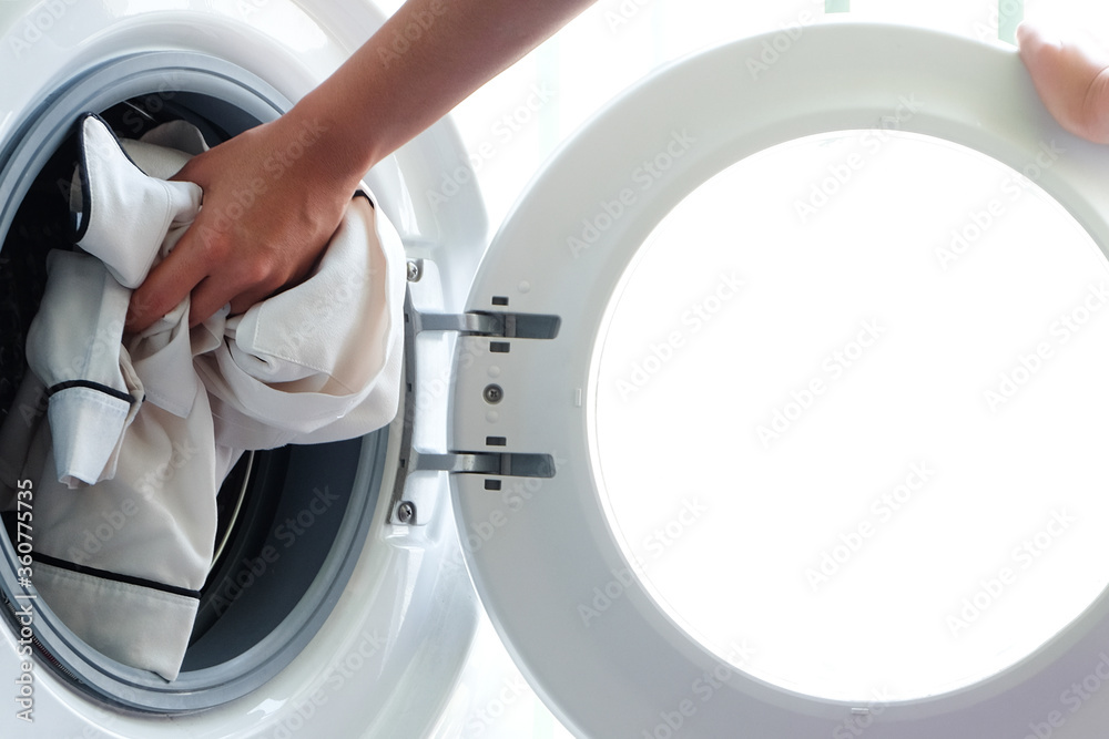 Woman's hand Pick up clothes Washing machine.Clean and Healthy Concepts. Woman's hand Pick up clothes Washing machine.Clean and Healthy Concepts.