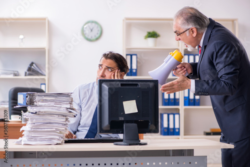 Old boss and young male employee in the office