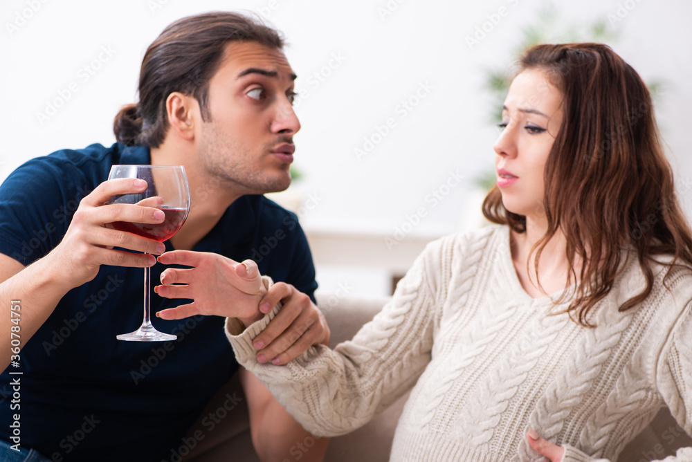 Man and pregnant woman in alcoholism concept Man and pregnant woman in alcoholism concept