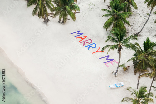 Fotografia Aerial drone view of the words Marry Me written in sand in colorful letters on a beach in Punta Cana, surprise proposal of marriage