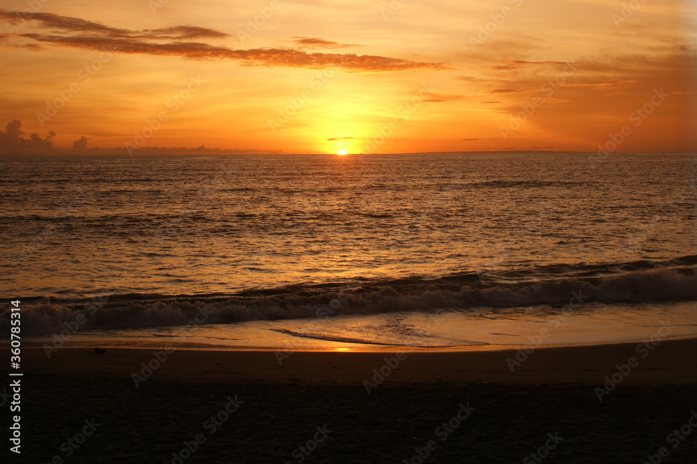 Sunset over Coast with sand and waves in orange color