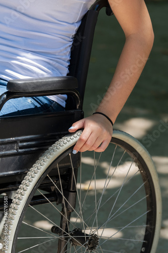 a female arm handling the wheel of a wheelchair . Disability and healthcare concept. © JeanPaul