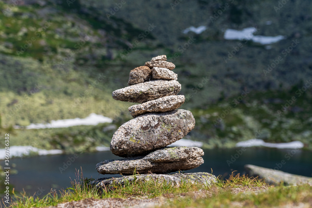 Relaxing pyramid of stones, against the backdrop of mountains and a lake Relaxing pyramid of stones, against the backdrop of mountains and a lake
