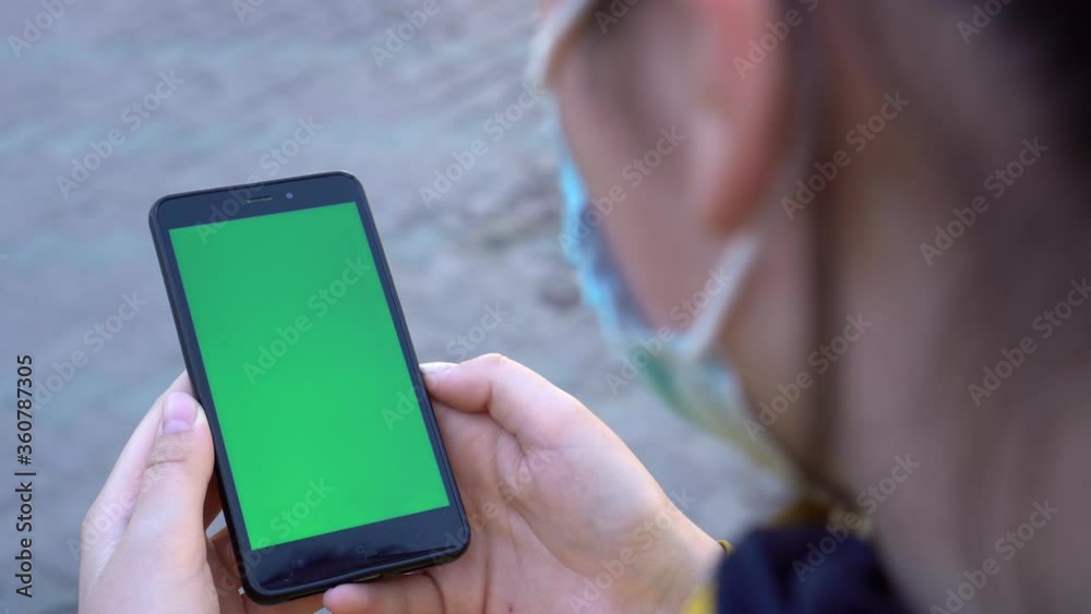 Close up of a woman's hand holding a mobile telephone with a vertical green screen in restaurant chroma key smartphone technology cell phone street touch message display hand