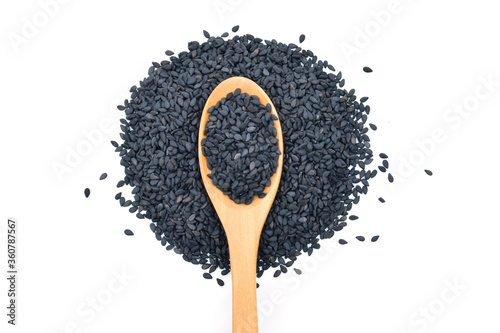 Black sesame seeds in wooden scoop on white background
