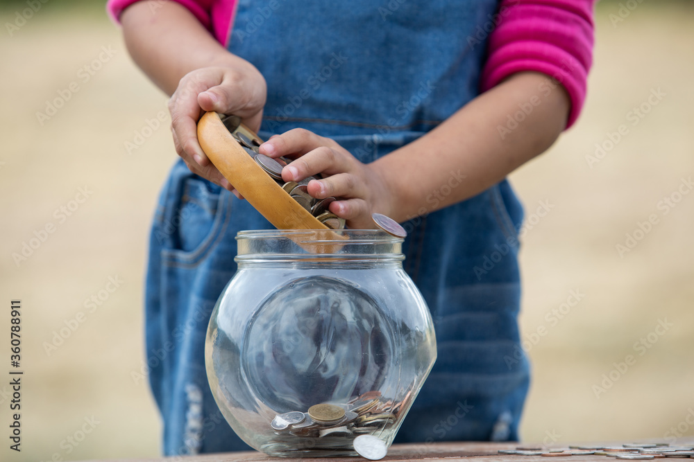 Obraz premium Little girl and pile coin for saving. money saving concept.