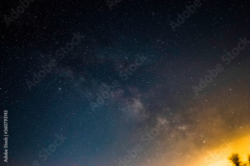 Fototapeta Naklejka Na Ścianę i Meble -  Milky Way in a Dark Sky Near a Small City