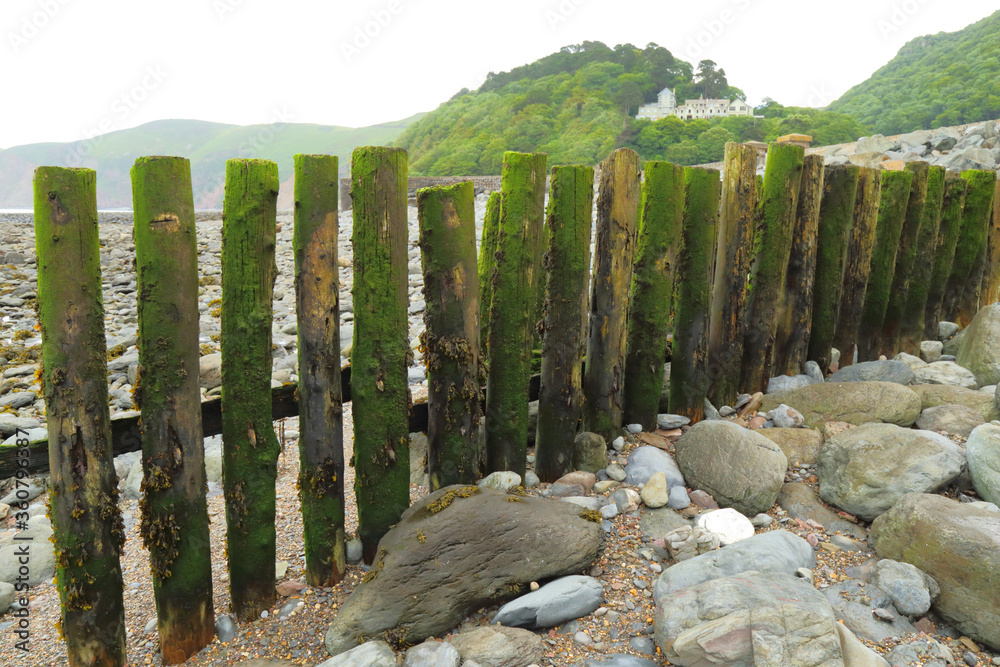 Fototapeta premium Weathered wooden groyne on the beach in village of Lynmouth, Devon