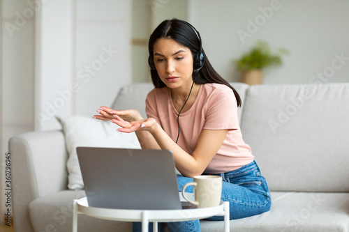 Obraz na plátne Woman Using Laptop Making Video Call Sitting On Couch Indoors